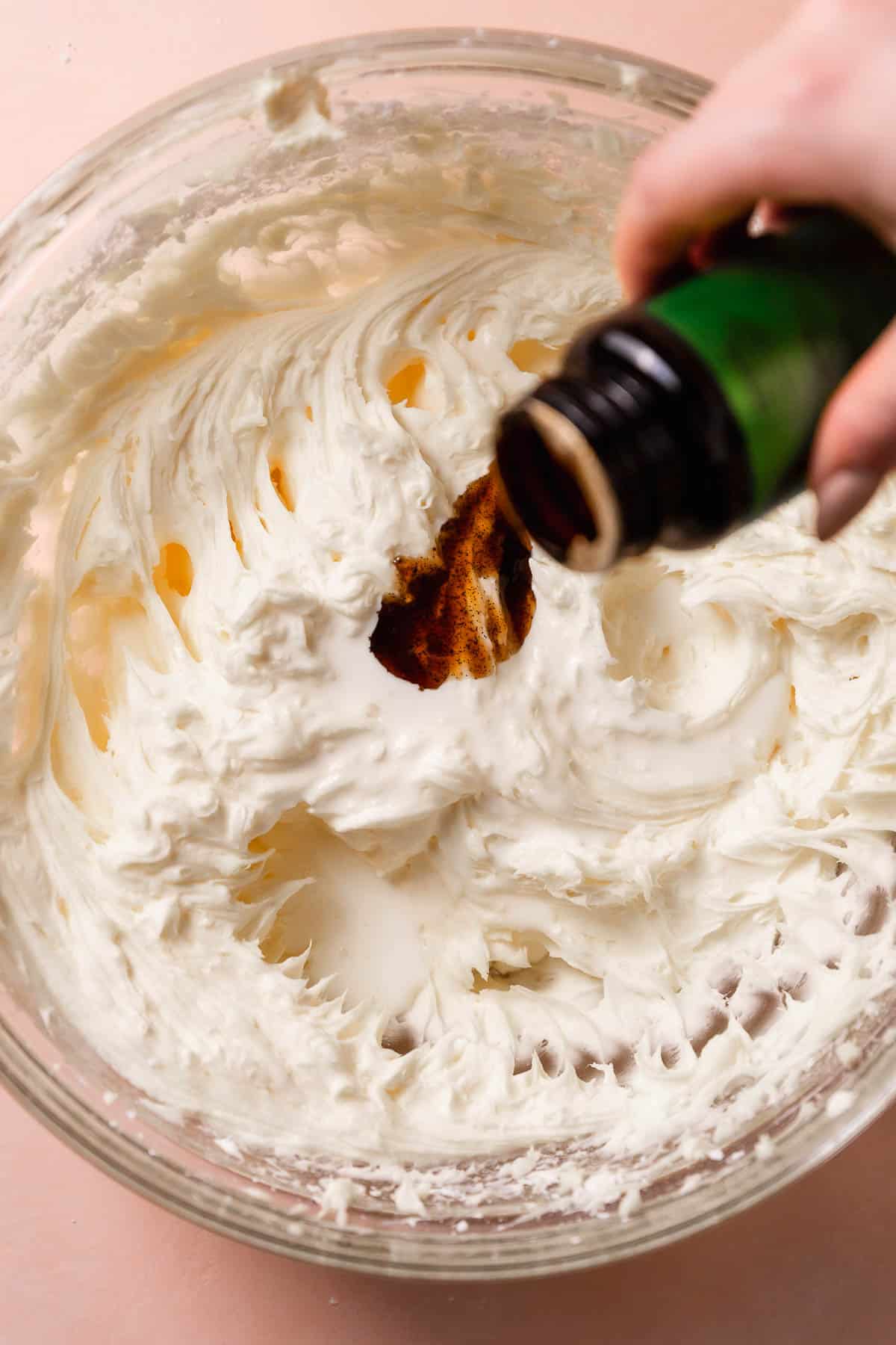 Vanilla bean paste being added to the cream cheese frosting.