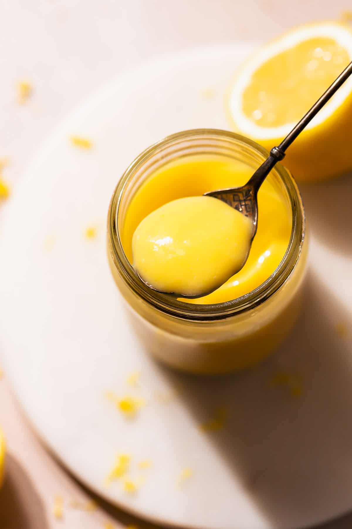 Lemon curd on a spoon showing the super creamy texture.