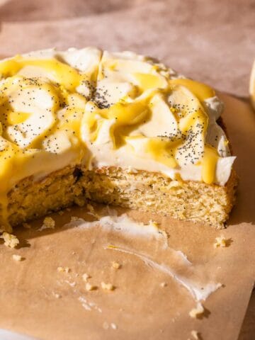 Lemon poppy seed cake on a brown parchment lined serving platter.