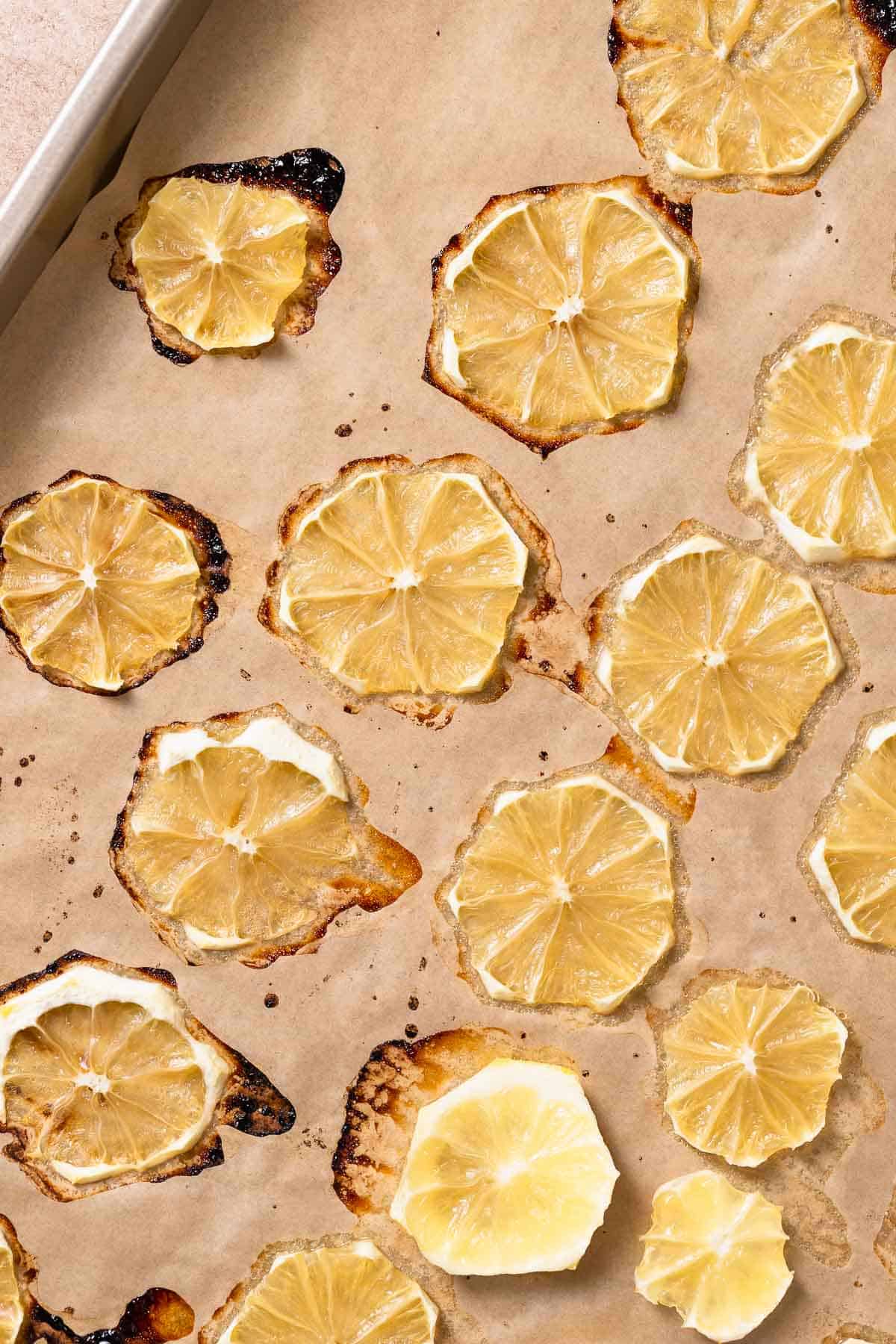 A sheet pan with roasted lemon slices on it.