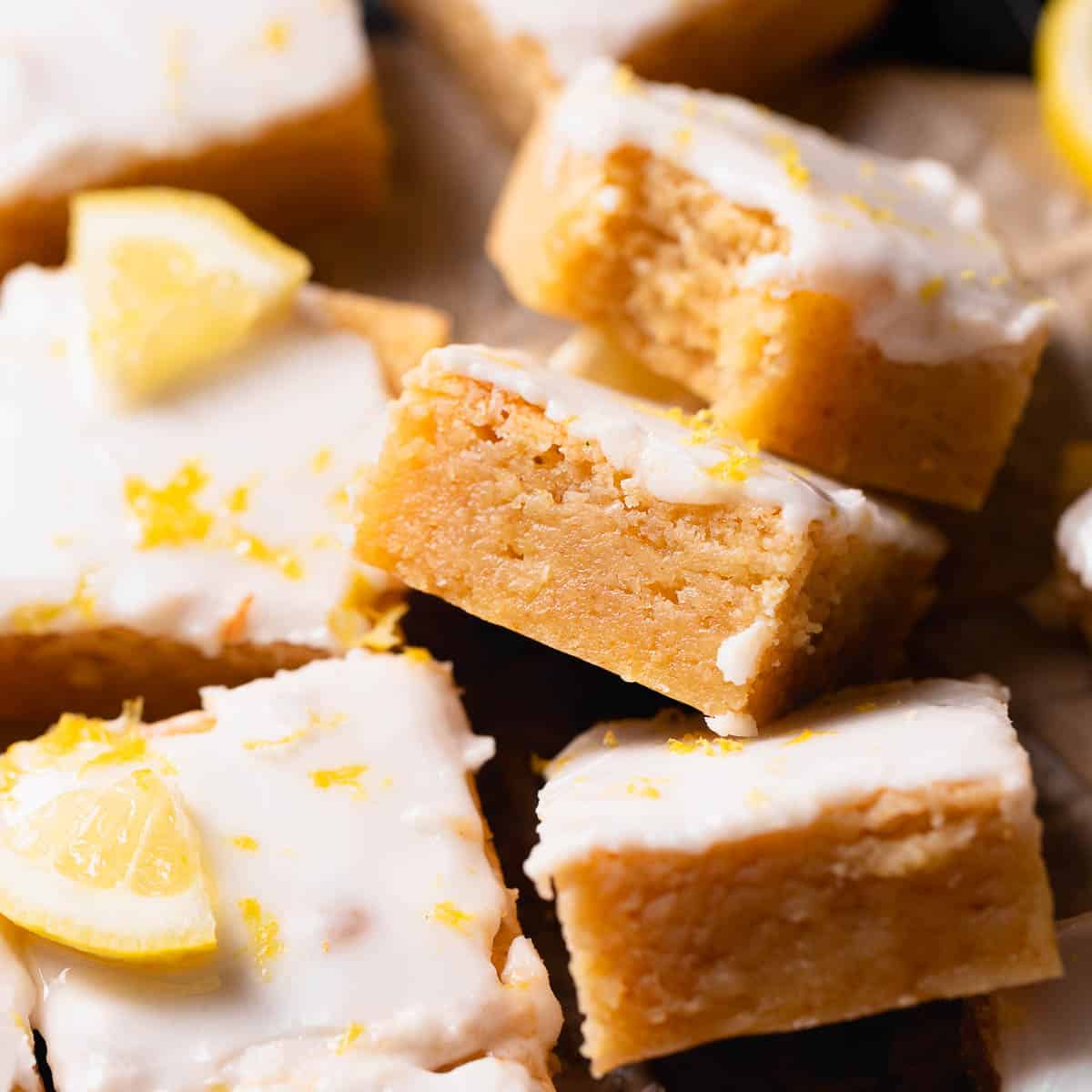 Fudgy lemon brownies with lemon icing and lemon zest on top.