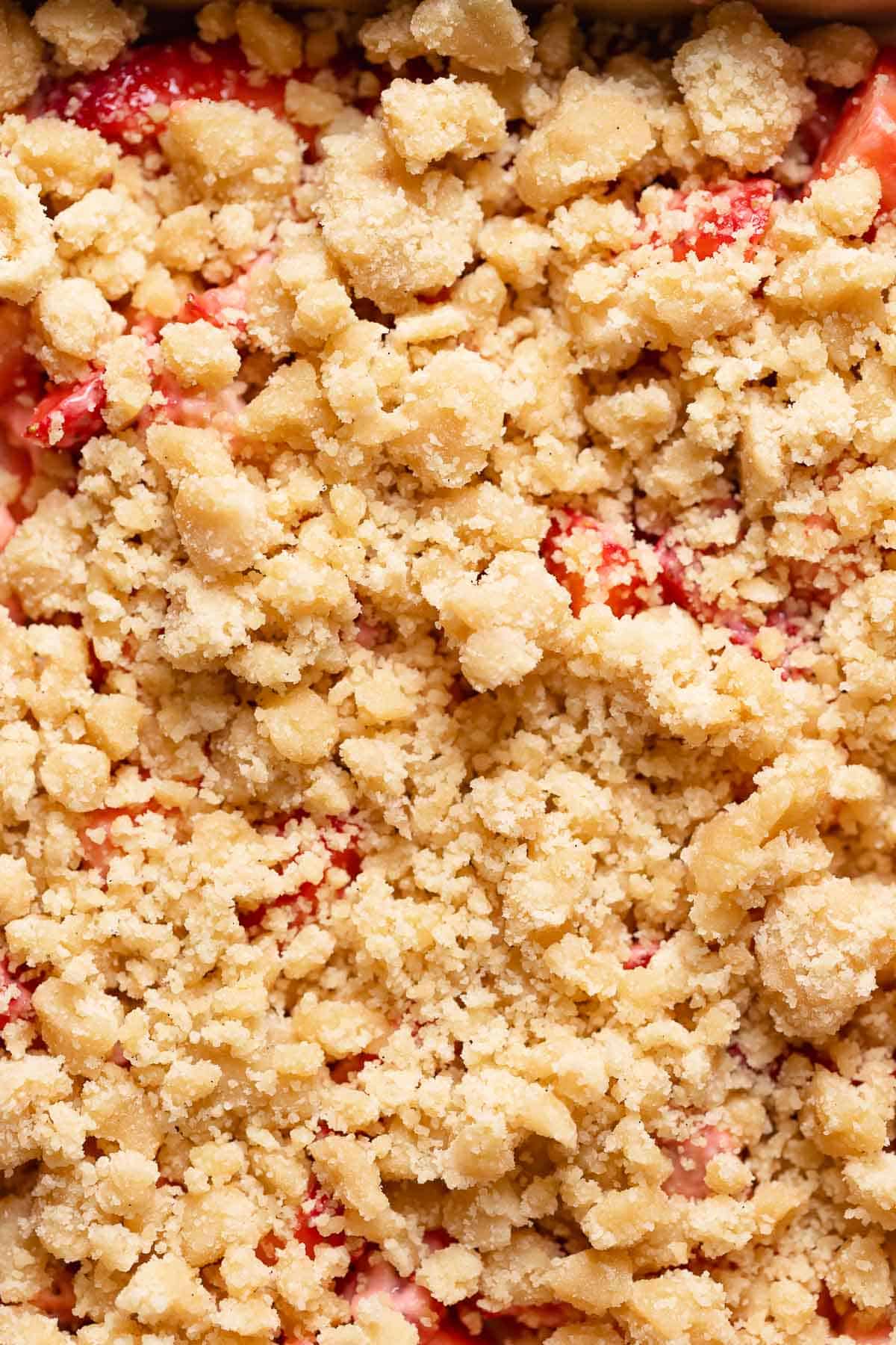 A close up shot of the crumb topping on top of the strawberries.