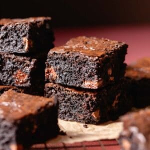 Black cocoa miso brownies on brown parchment paper.