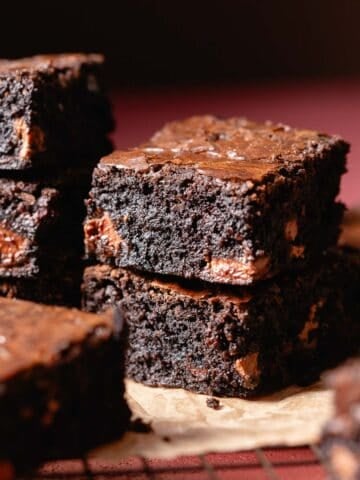 Black cocoa miso brownies on brown parchment paper.