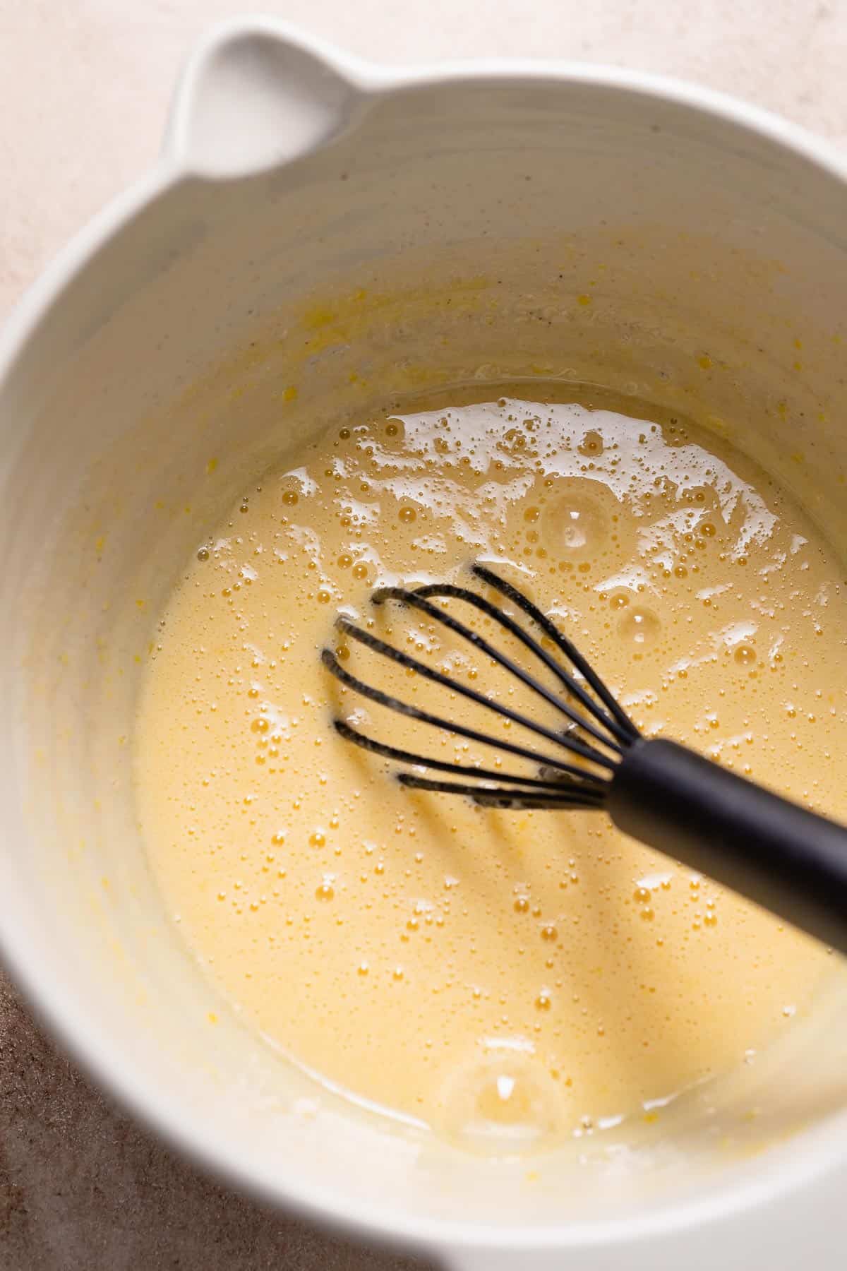 A mixing bowl with the whisked sugar and eggs.