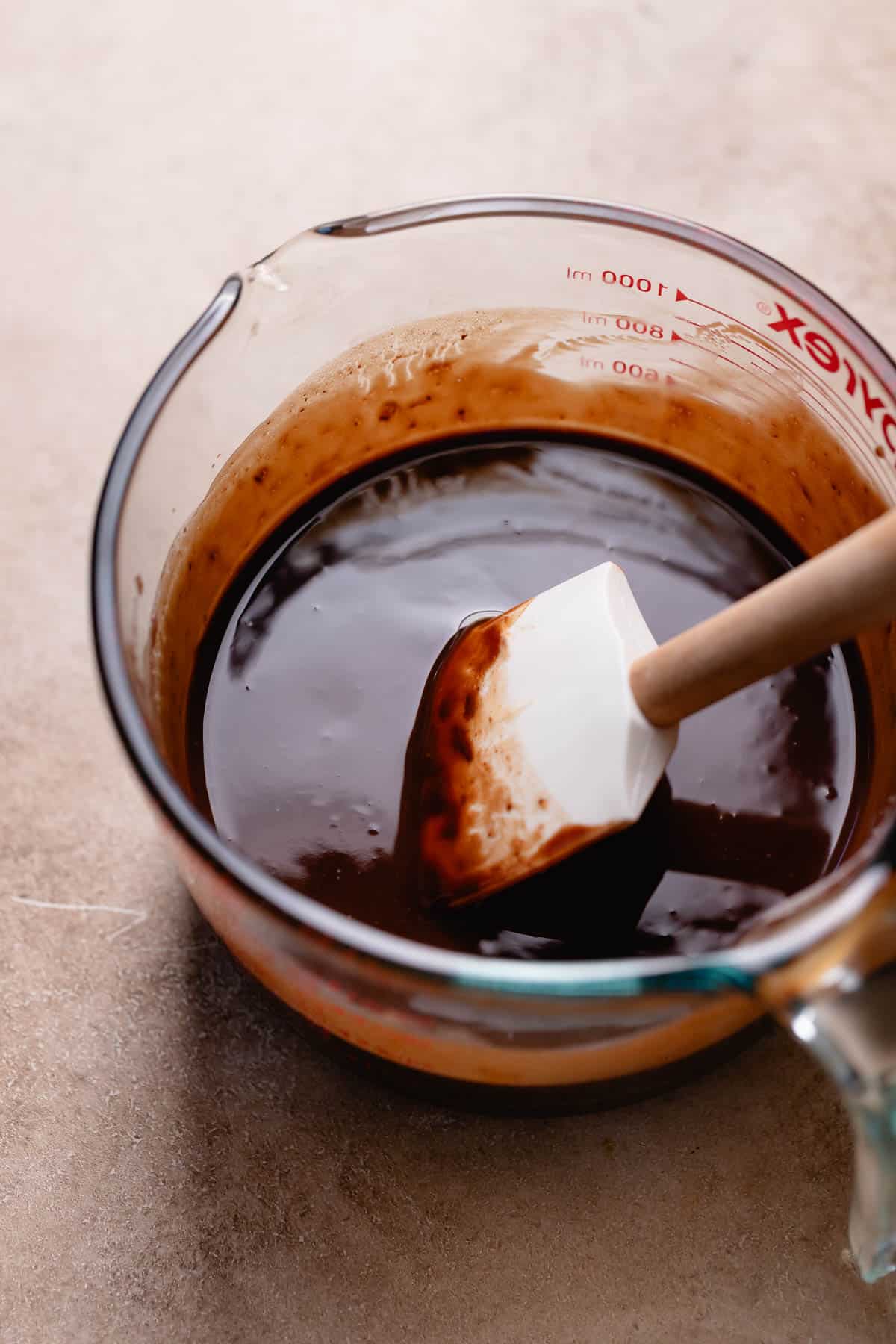 A glass bowl with the melted butter, chocolate, and miso paste.