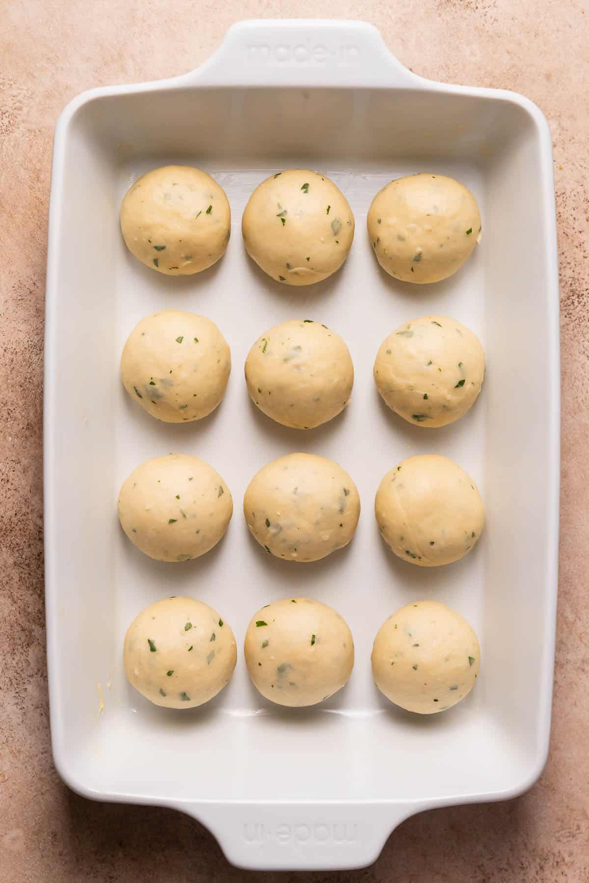 A baking pan with the garlic bread rolls before they've risen.