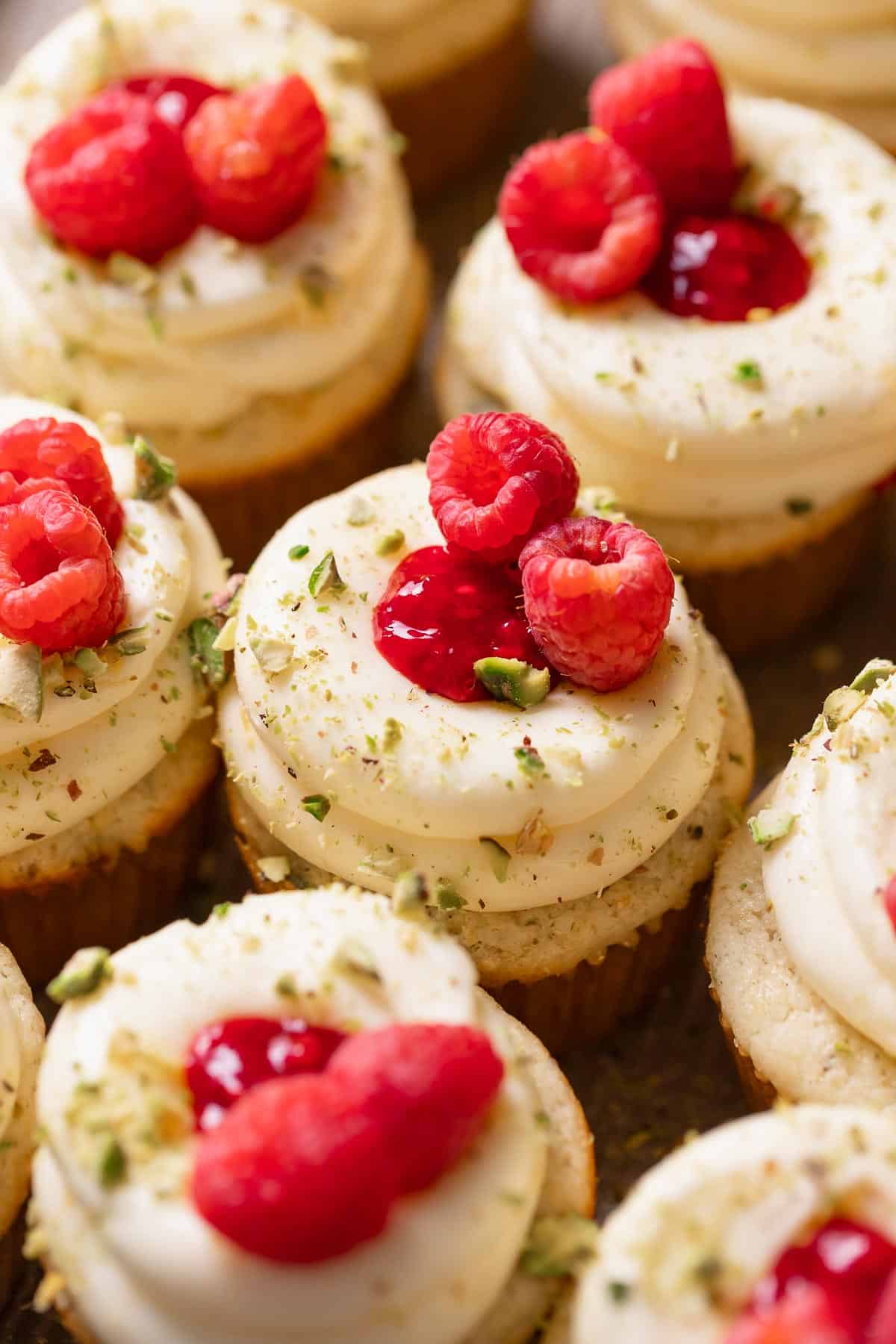 Lemon and raspberry cupcakes topped with lemon frosting and fresh raspberries.