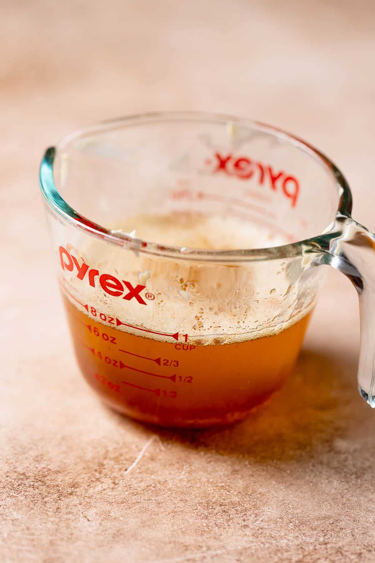 A glass measuring cup with browned butter.