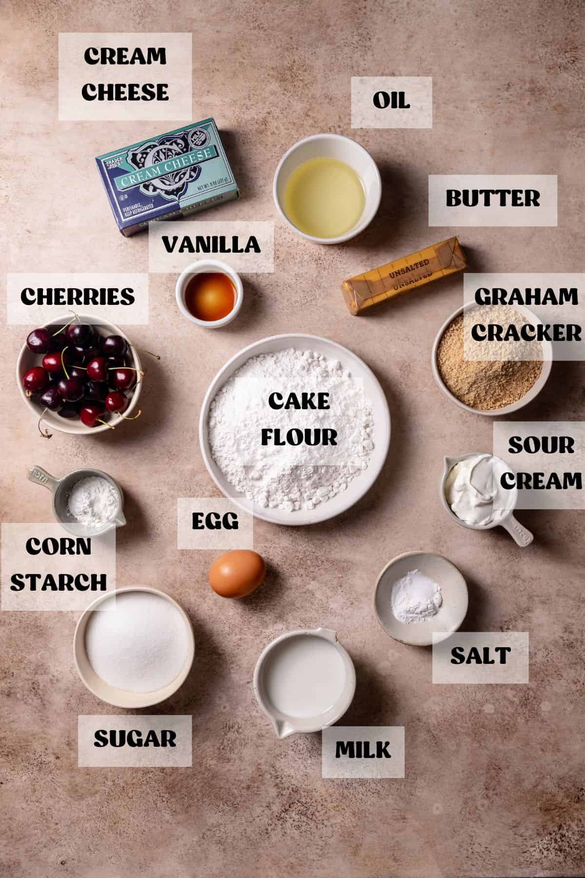 Ingredients needed to make cherry cupcakes in bowls with labels.