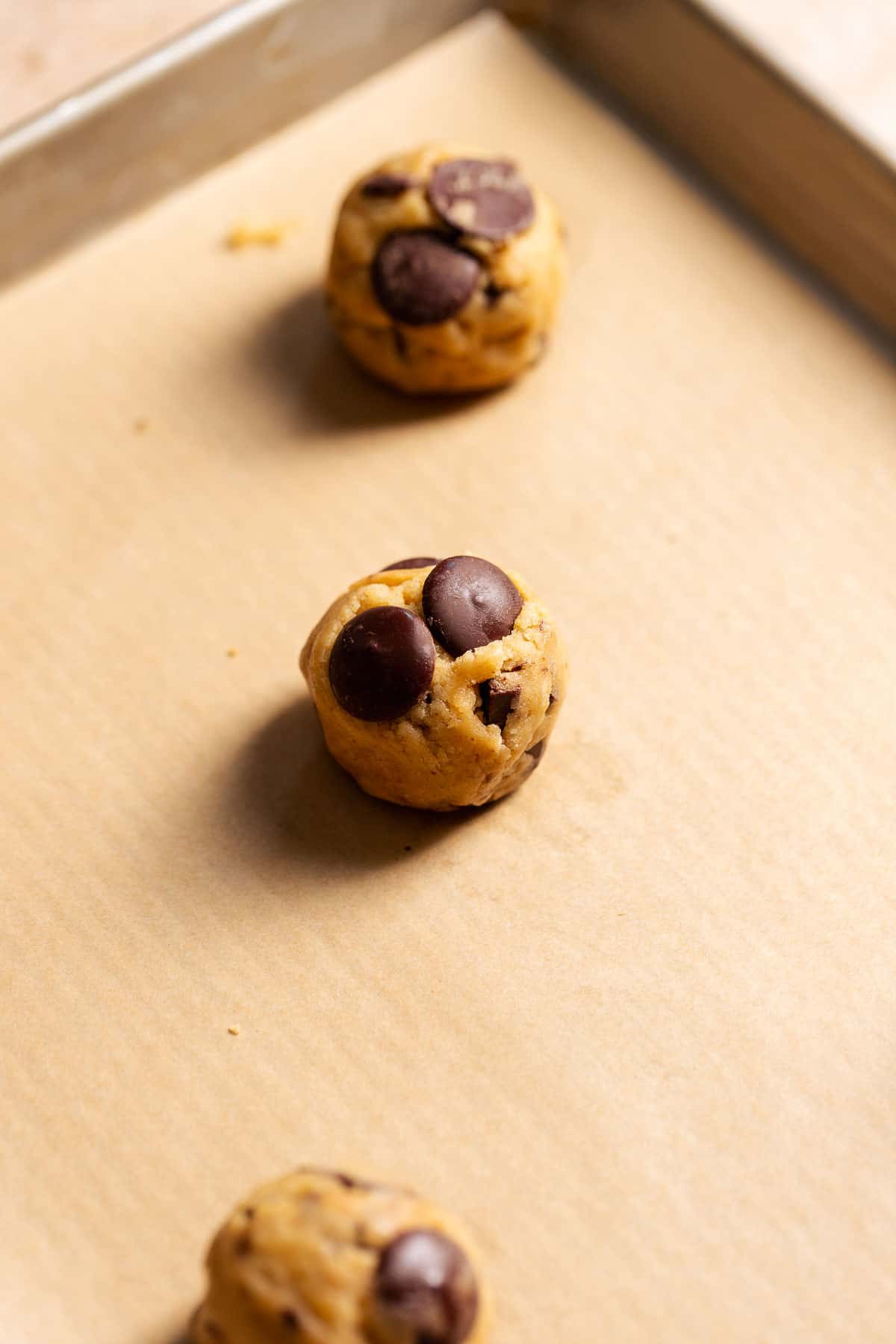 Balls of cookie dough on a baking sheet right before baking.