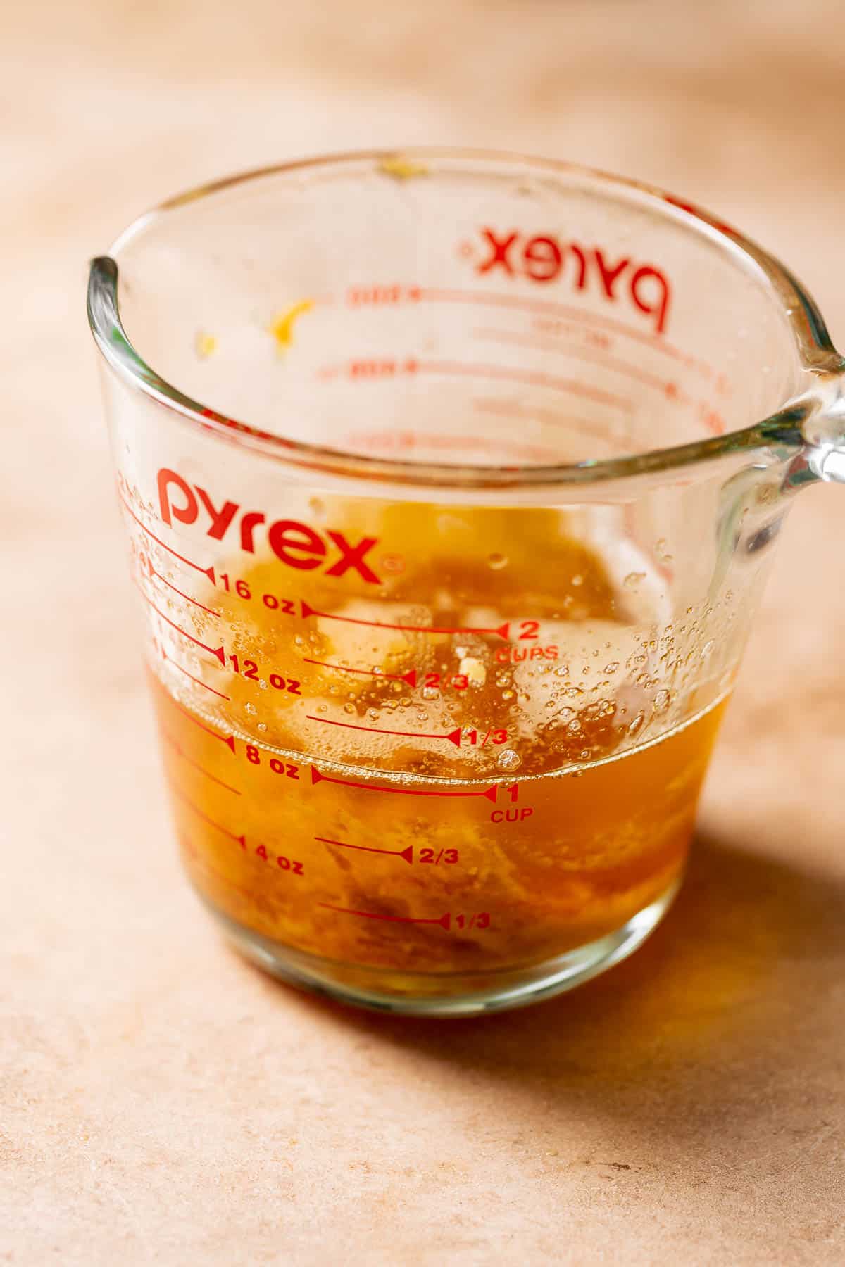 A glass measuring cup with the brown butter and miso paste.