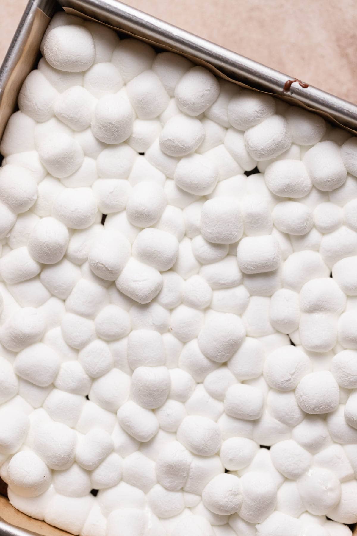 An up close shot of the puffy mini marshmallows on top of the brownie layer.