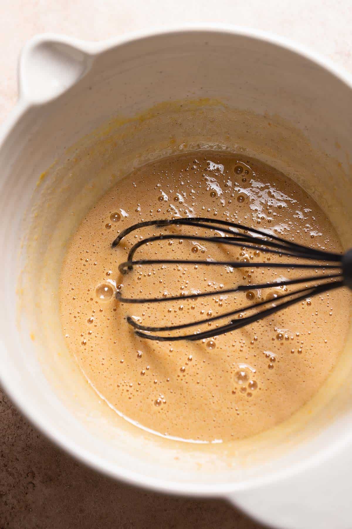 A mixing bowl with the whisked sugar and eggs.