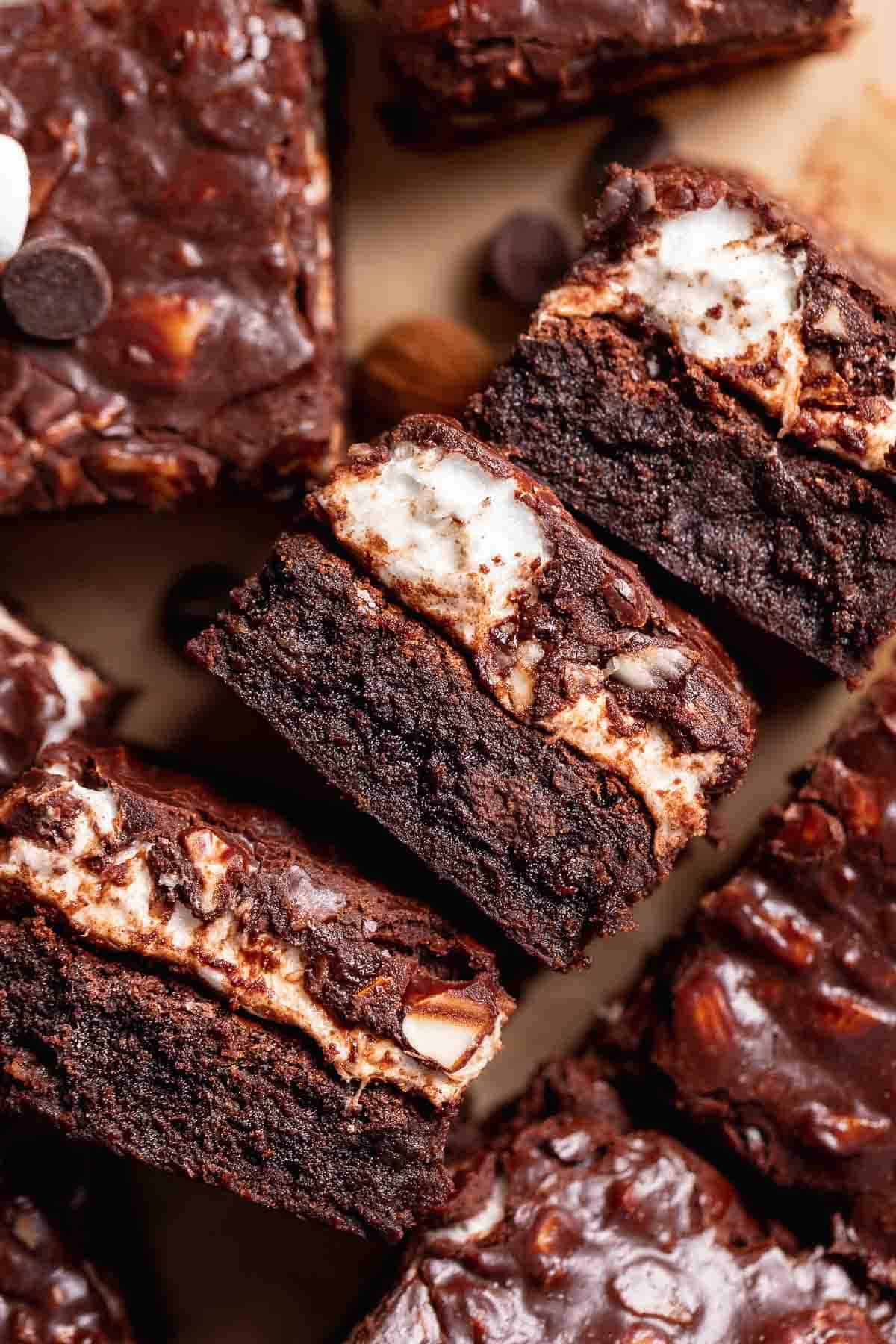 Rocky road brownies on their sides to show the brownie, marshmallow, and almond layers.
