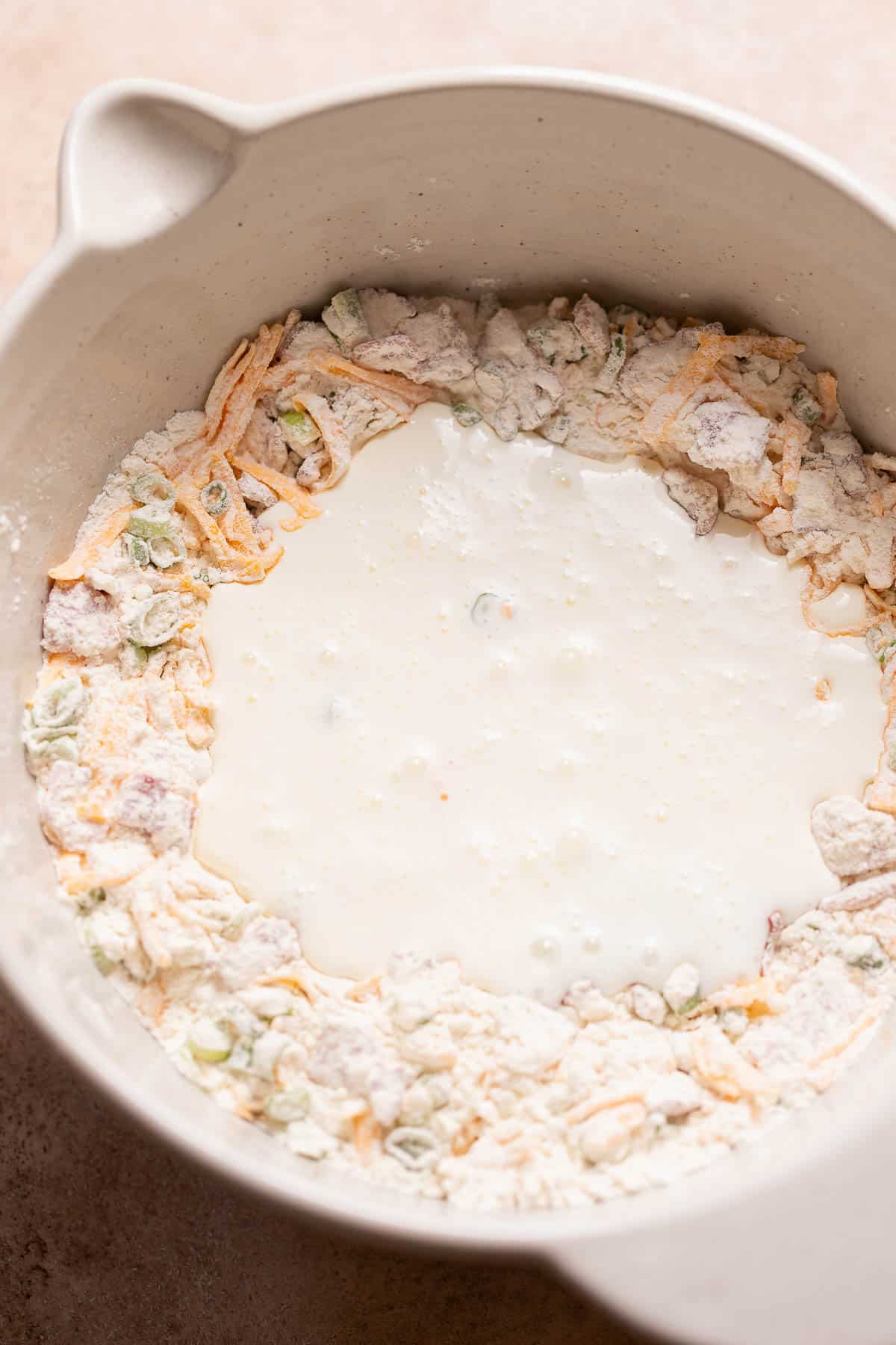 A mixing bowl with the cream poured into the center of the dry ingredients.