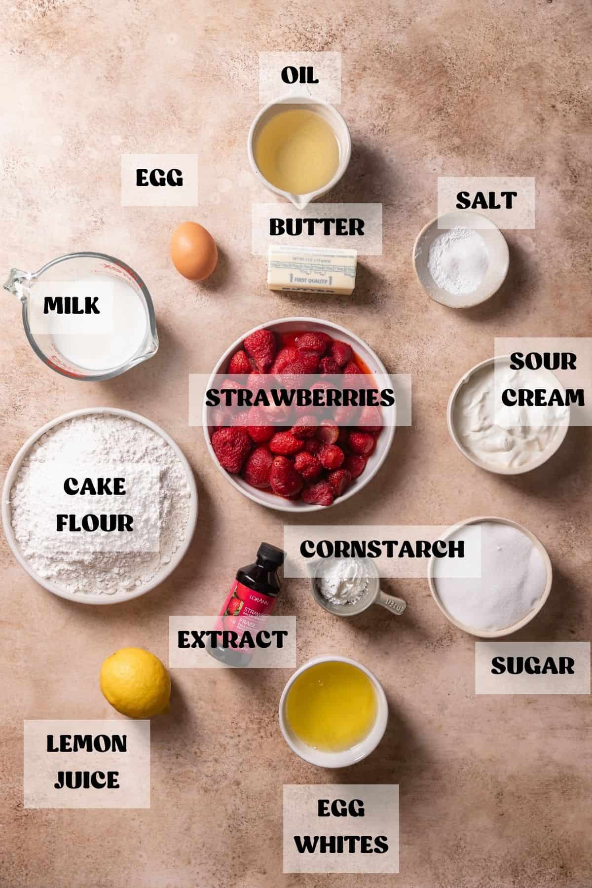 Ingredients needed to make homemade strawberry cake in bowls with labels.