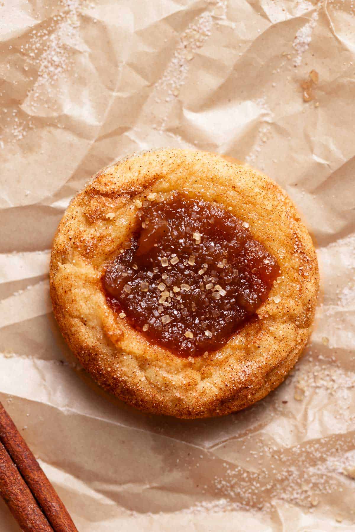 An apple butter cookie on brown parchment paper right after baking.