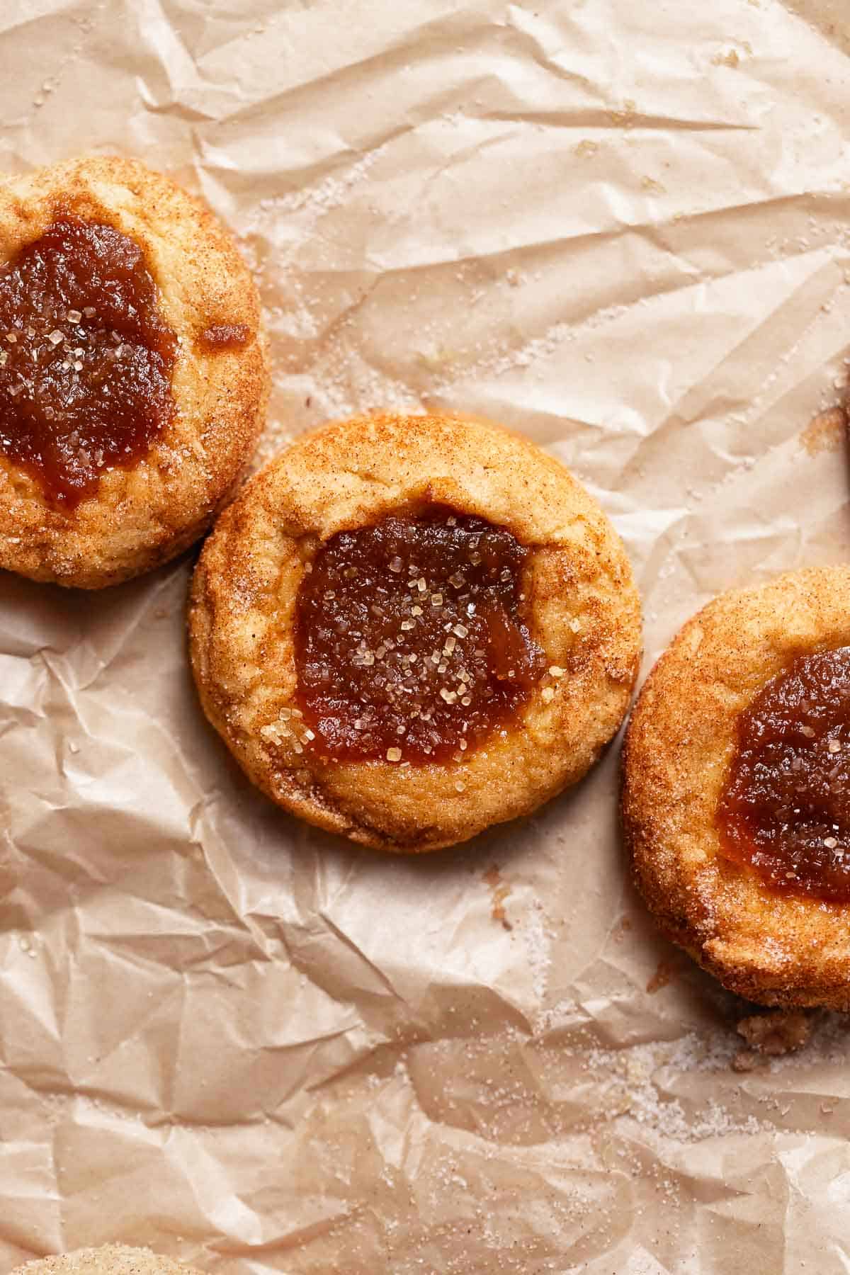 Snickerdoodle cookies filled with apple butter on brown parchment paper.