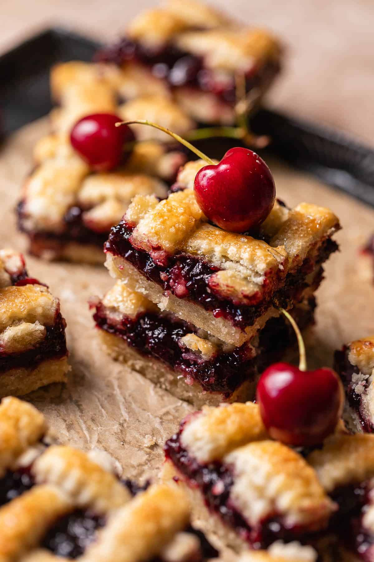 Two cherry pie bars on top of each other to show the juicy cherry filling.