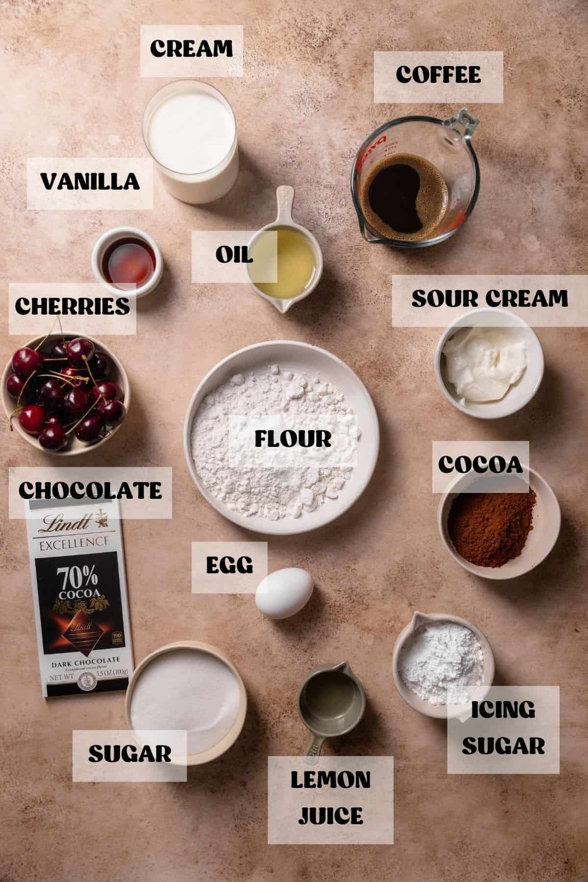 Ingredients needed to make cherry chocolate cake in bowls with labels.