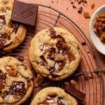 Brown butter toffee chocolate chip cookies on a wire cooling rack.