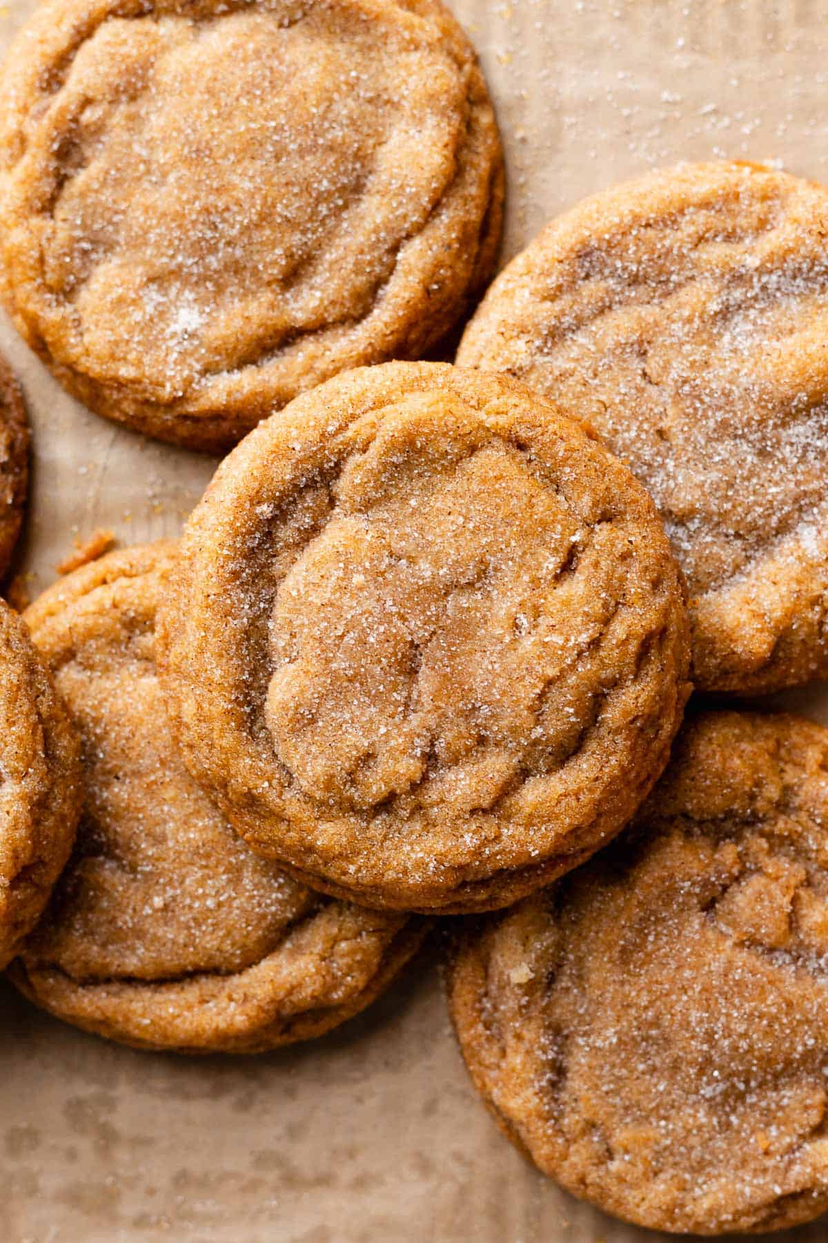 Pumpkin snickerdoodles on brown parchment paper.