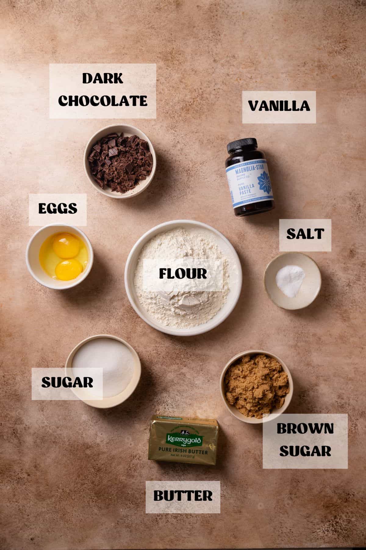 Ingredients needed to make brown butter toffee cookies in bowls with labels.