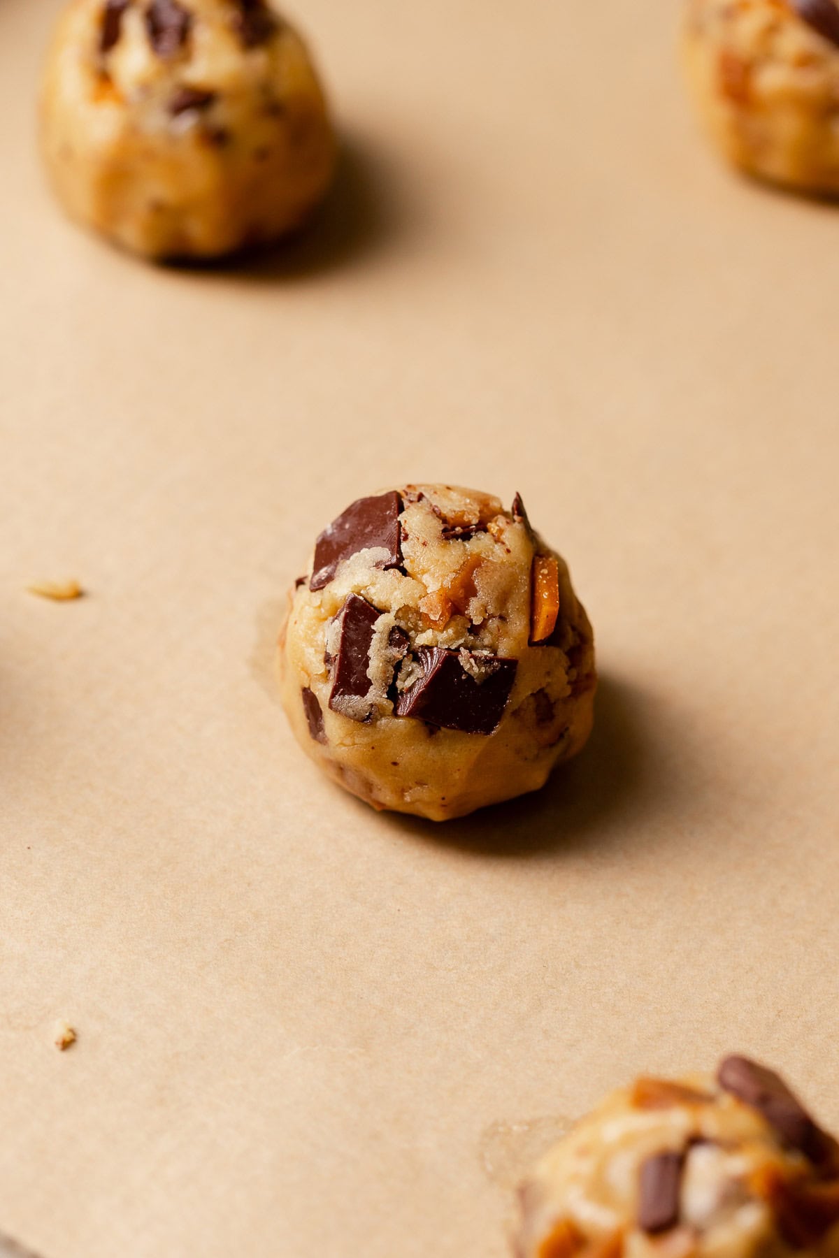 Toffee cookie dough balls on a baking sheet before baking.