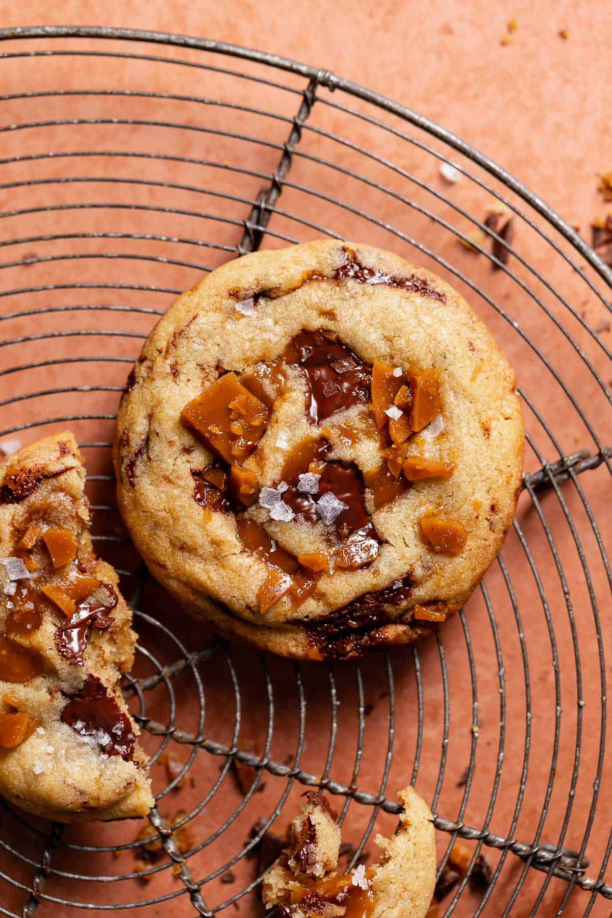 Chocolate chip toffee cookie on a wire cooling rack after baking.