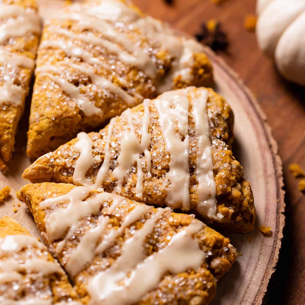 Pumpkin scones with maple glaze on a wooden board.