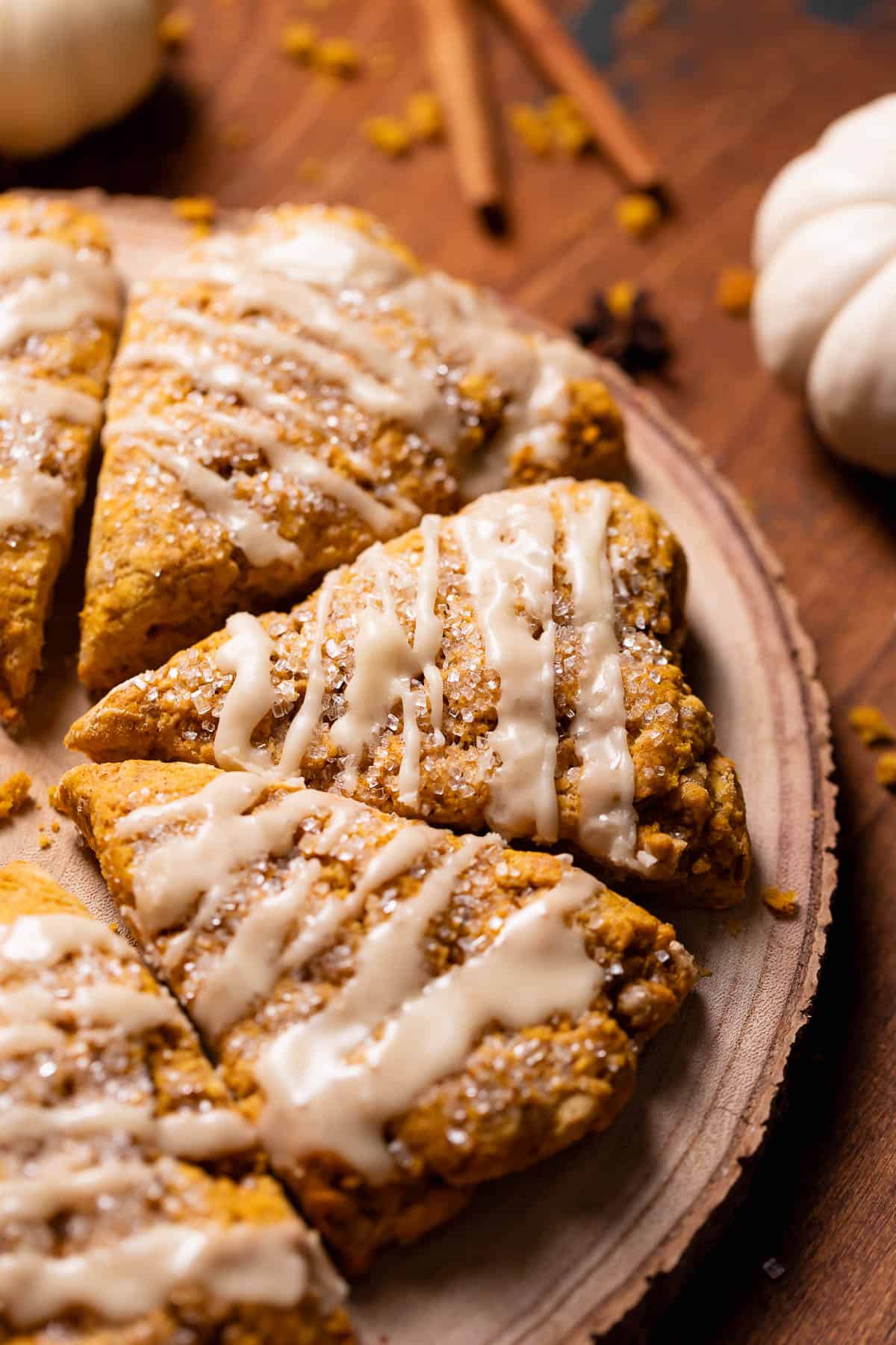 Pumpkin scones with maple glaze on a wooden board.