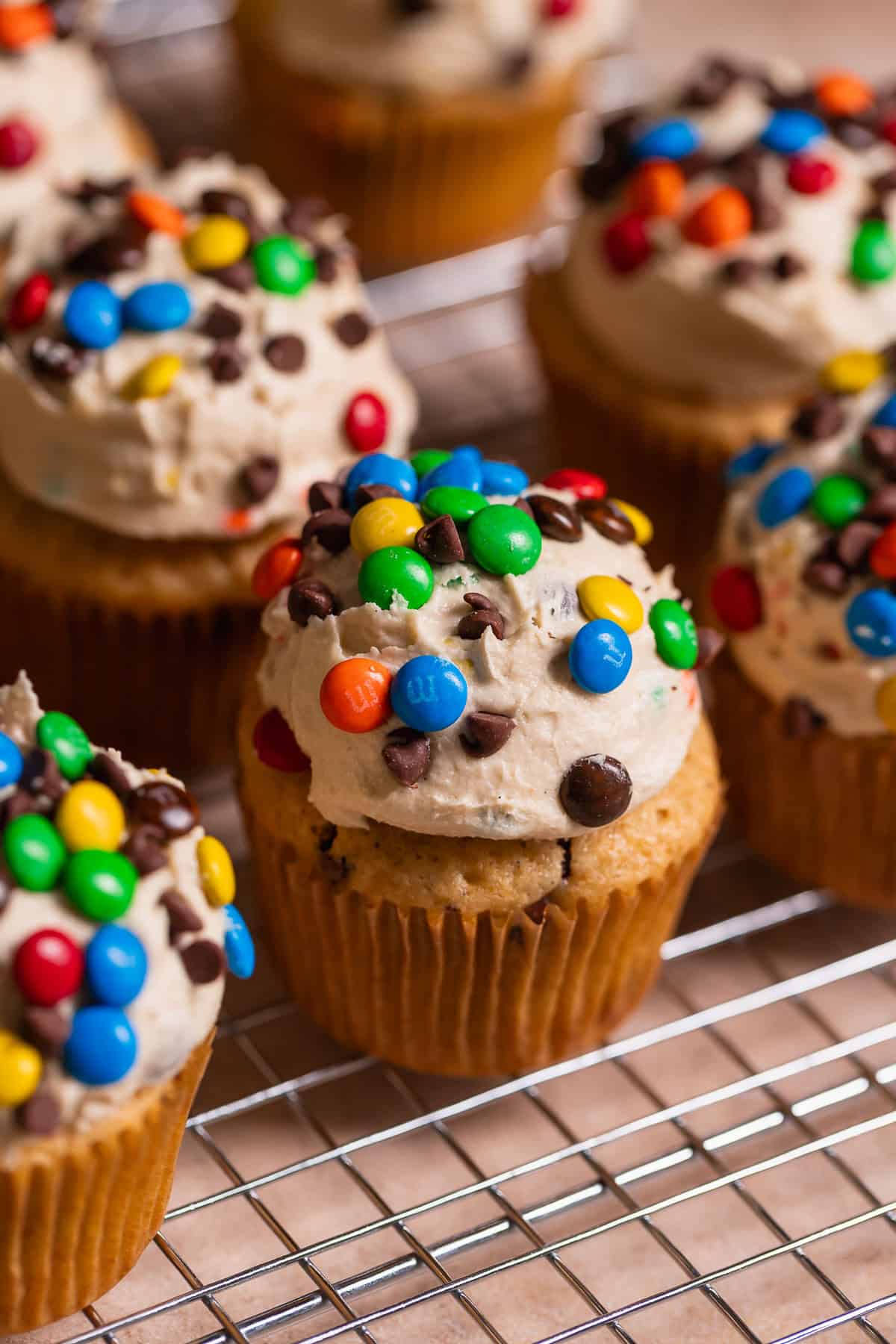 Monster cookie cupcakes on a wire rack after decorating.