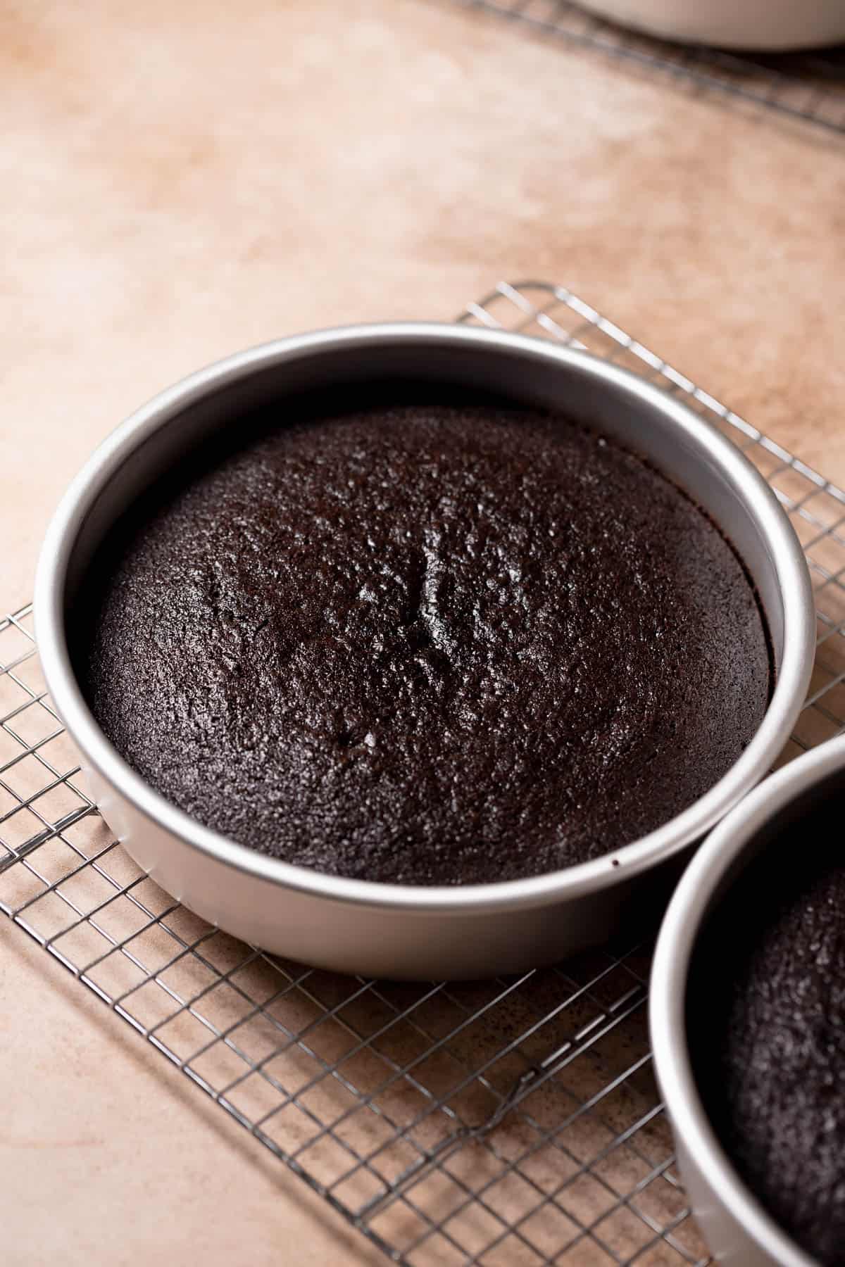 The chocolate cake layers cooling on a wire rack.