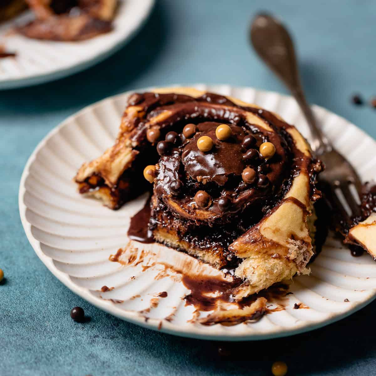 A chocolate sweet roll on a white plate.