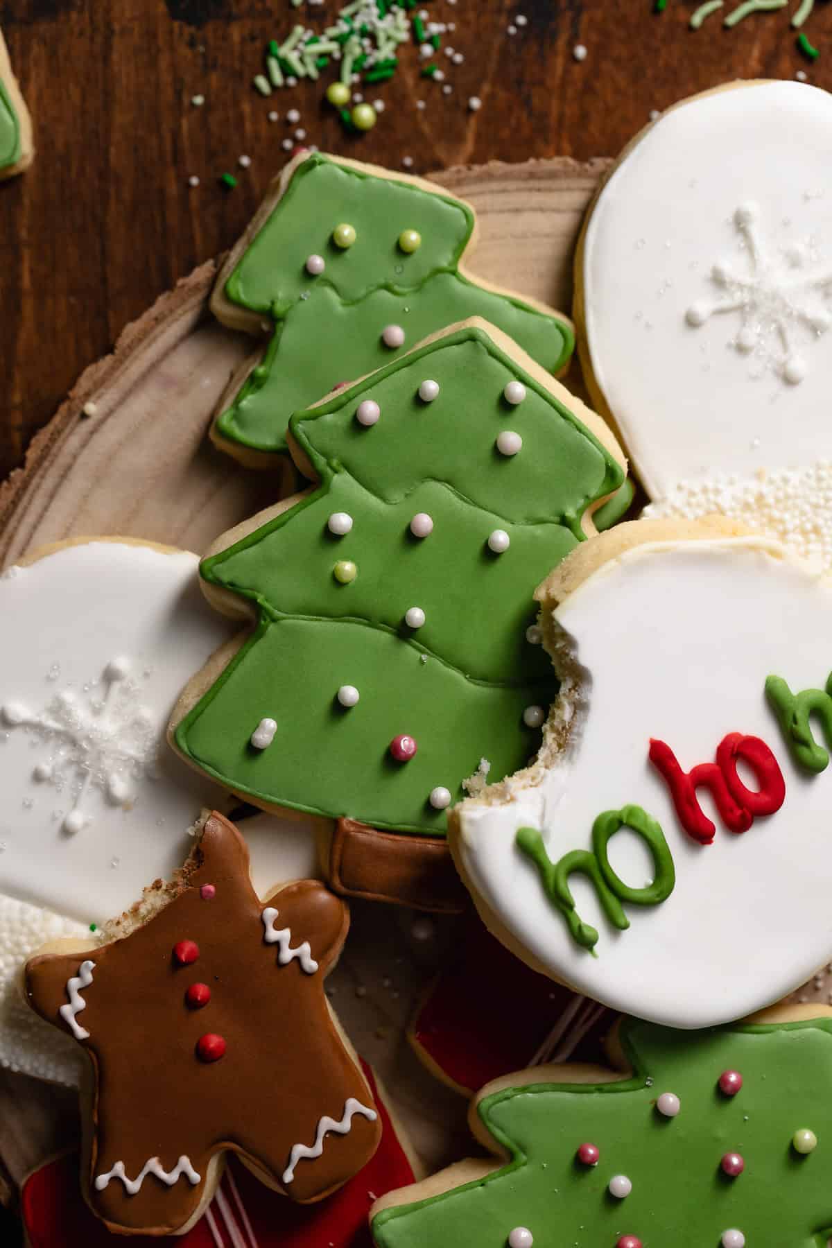 Christmas sugar cookies with royal icing decorations on a plate.