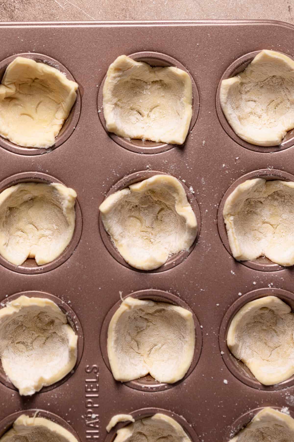 A mini muffin pan with the puff pastry pressed into the cups.