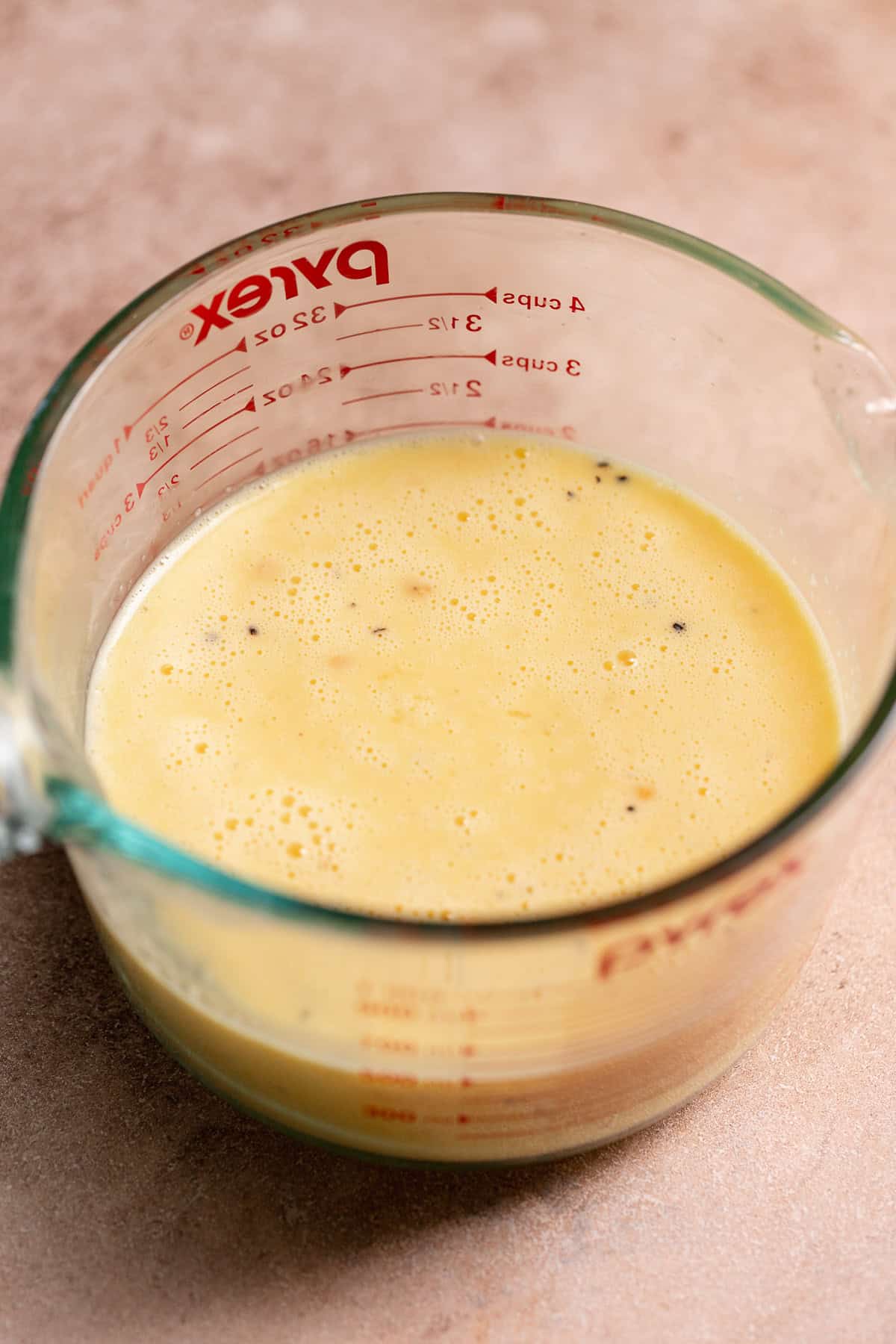 A glass mixing bowl with the egg filling mixture.