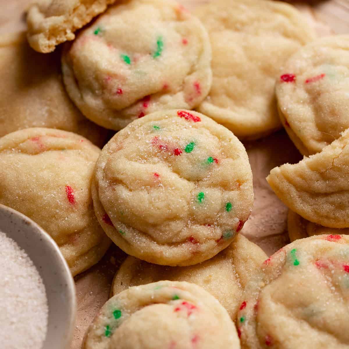 Homemade sugar cookies in a pile on a tray.