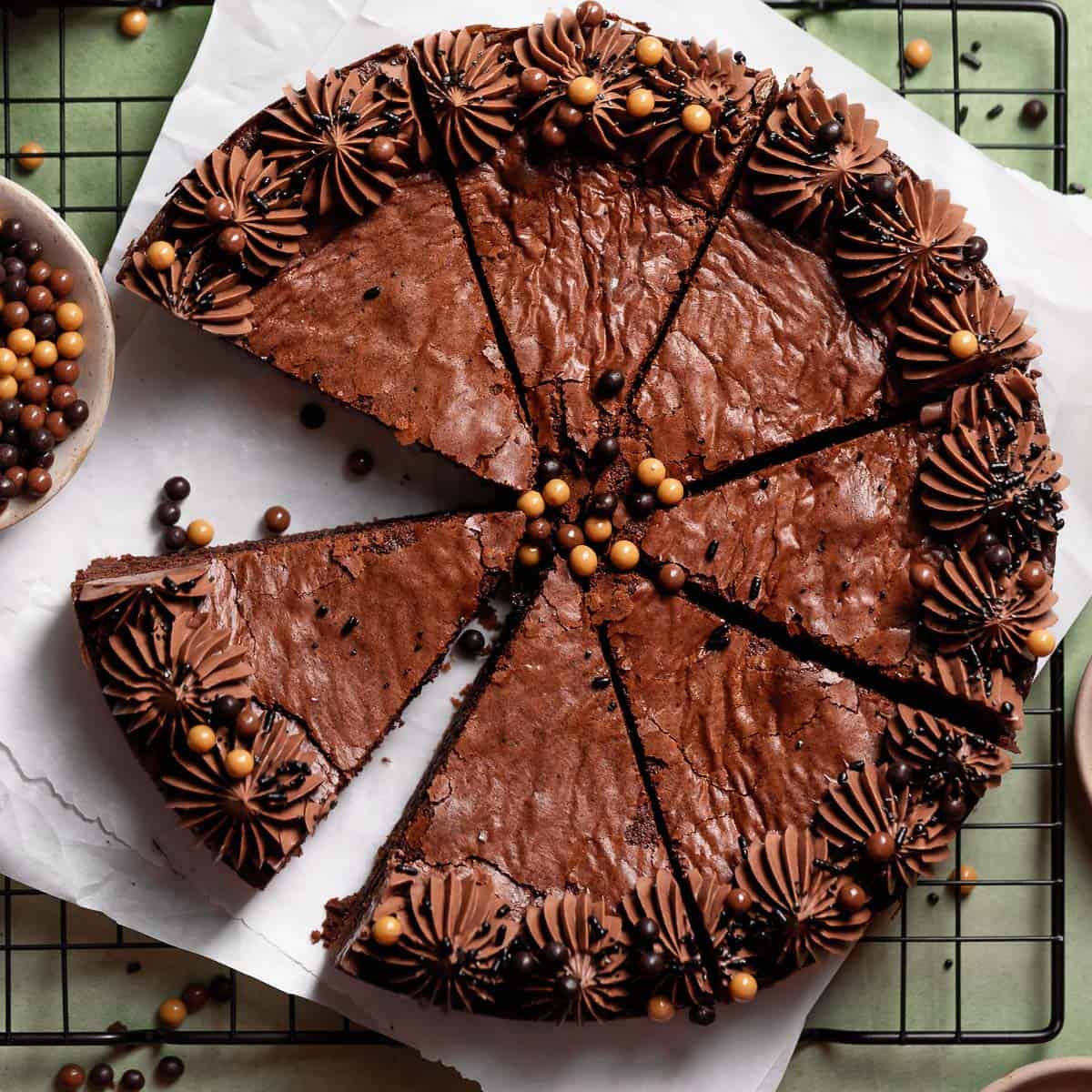 Brown butter brownie cake cut into slices on parchment paper.