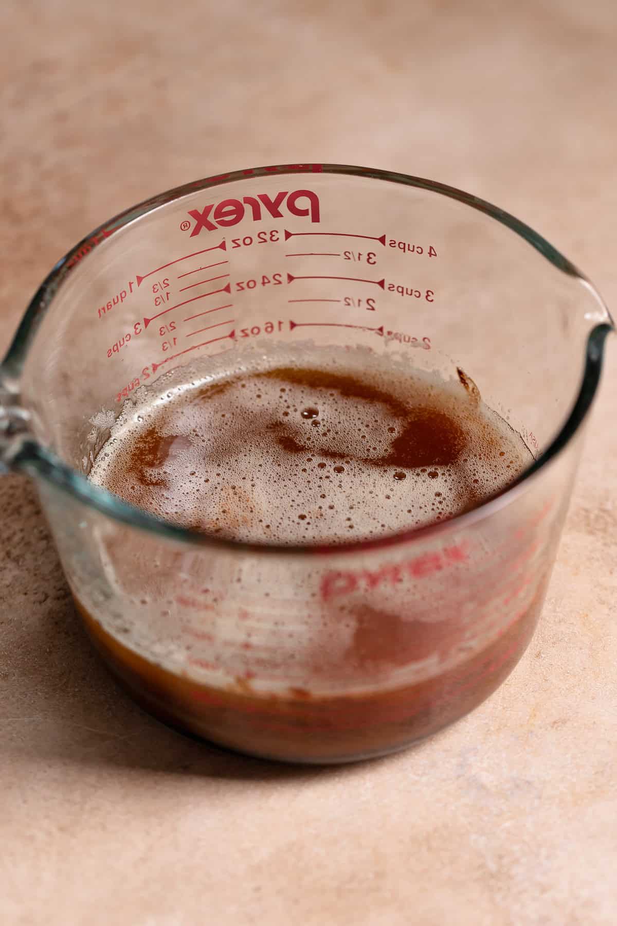 Melted brown butter and chocolate in a glass measuring cup.