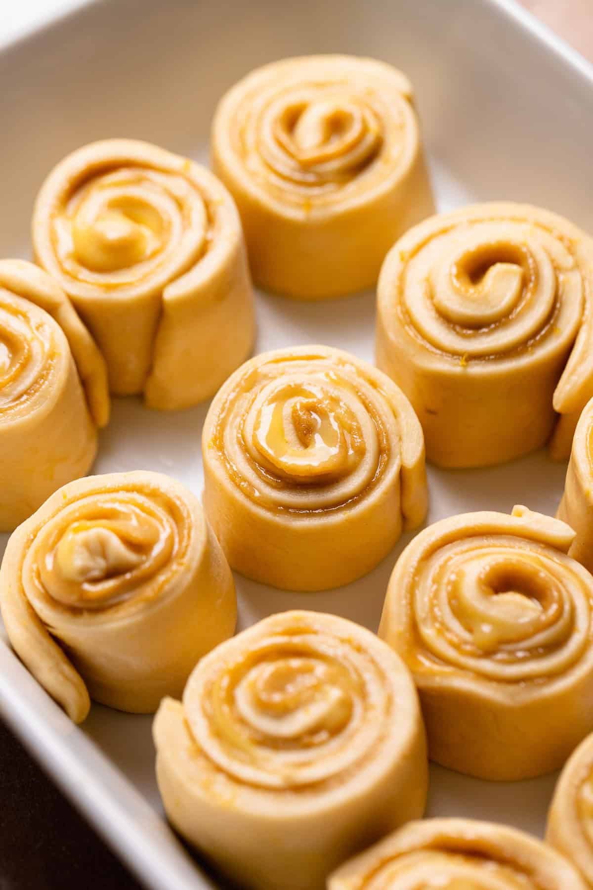 Lemon buns in a baking pan before rising.