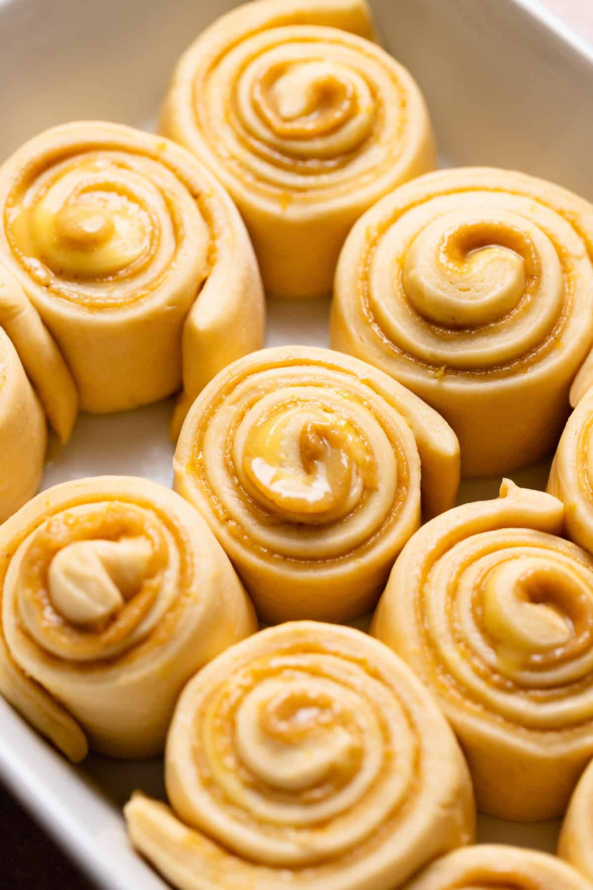 The sweet buns in a pan after they have doubled in size.