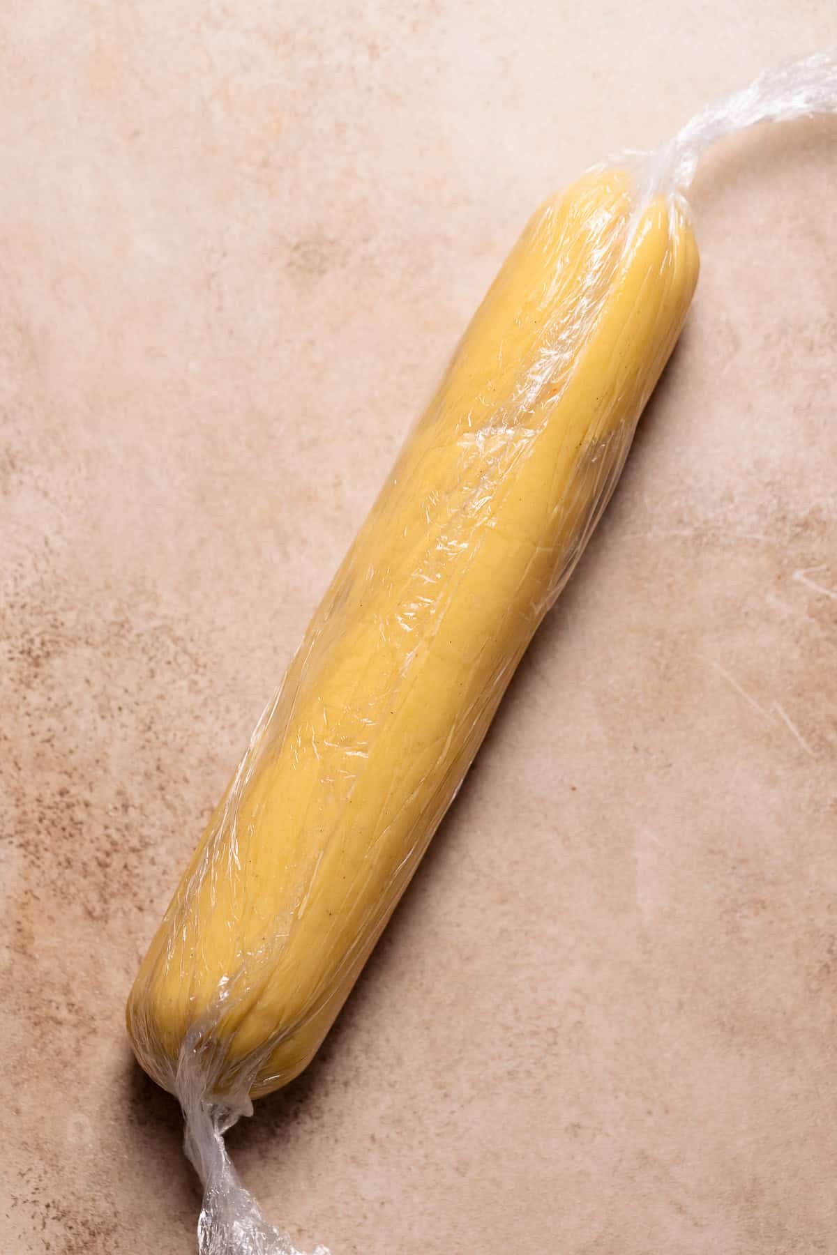 The log of cookie dough wrapped in plastic wrap.