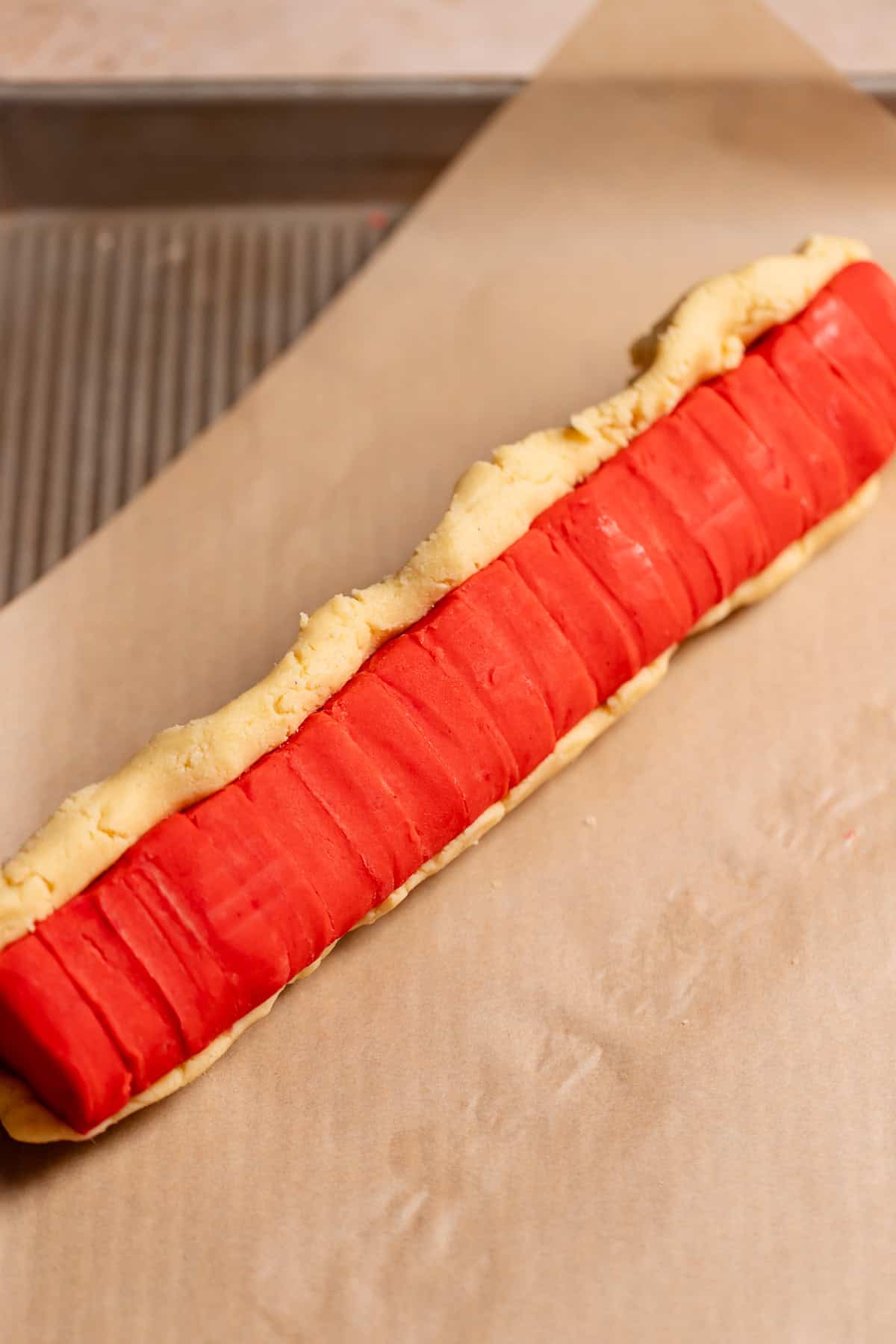 The log of hearts being covered with the regular sugar cookie dough.