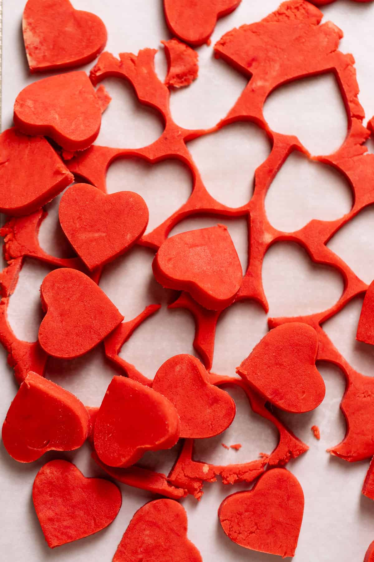 Heart cookie cut outs on parchment paper.