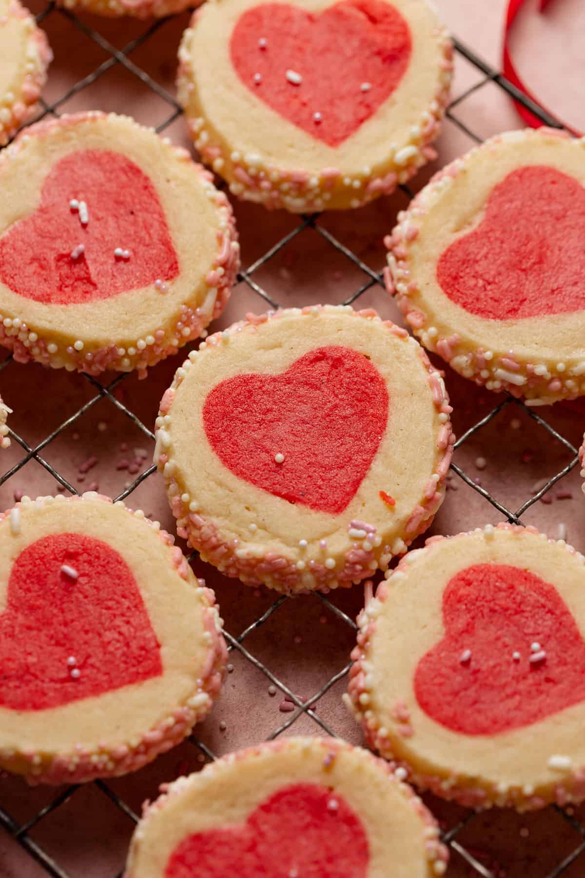 Slice and bake cookies on a wire rack with pink sprinkles throughout.