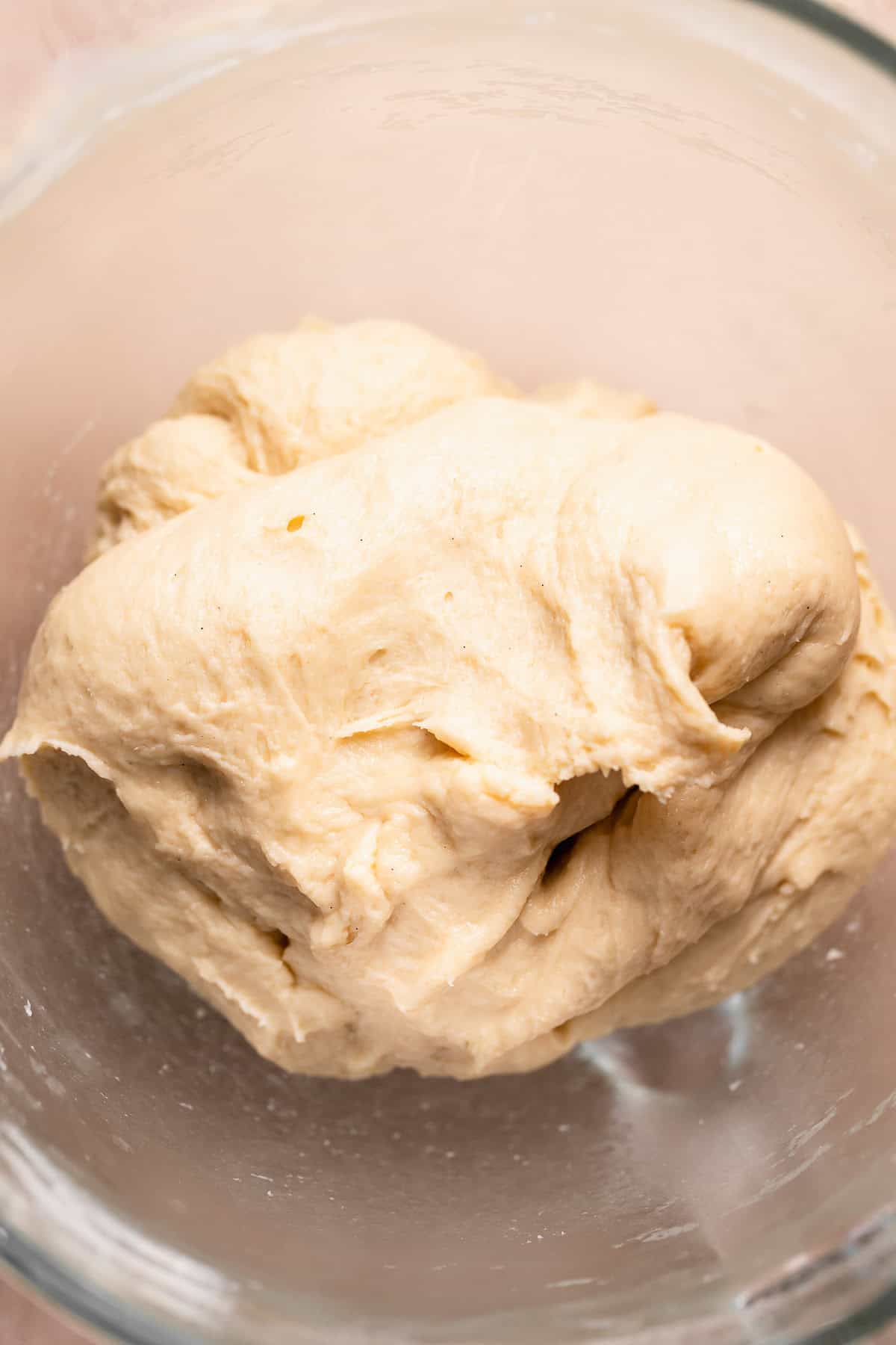 The soft and smooth dough ball in a mixing bowl.