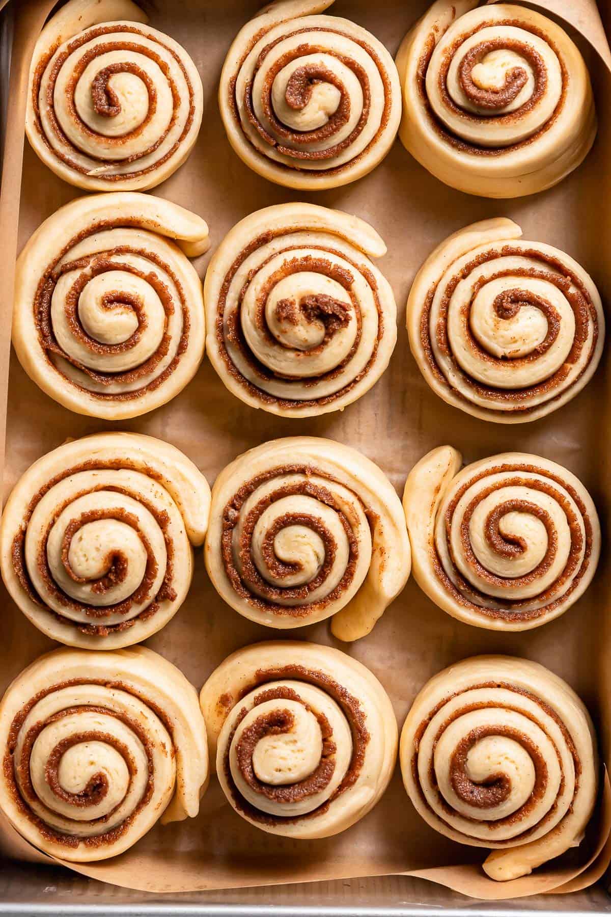 Cinnamon buns in the baking pan after doubling in size.