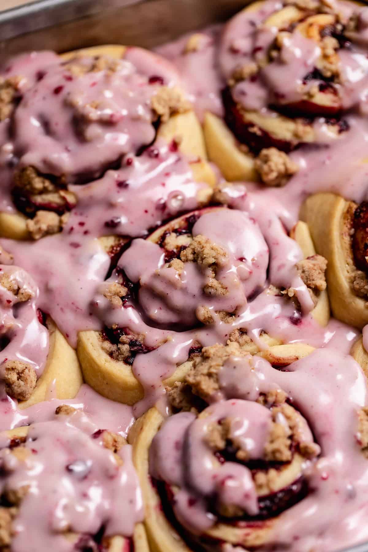 A side view of the baked rolls with the sweet berry glaze on top.